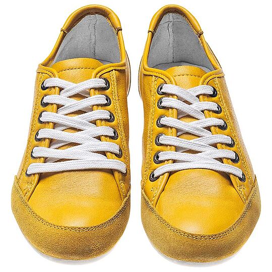 A pair of yellow shoes with white shoelaces